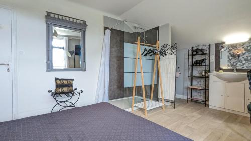 sypialnia z łóżkiem, umywalką i lustrem w obiekcie La Maison w mieście Mirebeau-sur-Bèze