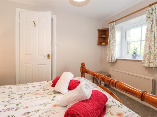a bedroom with a bed with red and white towels on it at Bakers Yard Cottage in Ambleside