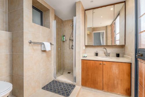 La salle de bains est pourvue d'une douche, d'un lavabo et de toilettes. dans l'établissement Full Option 3BR next King David, à Jérusalem