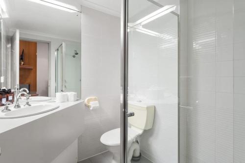 a bathroom with a shower and a toilet and a sink at The Hidden Gem - Adelaide CBD in Adelaide