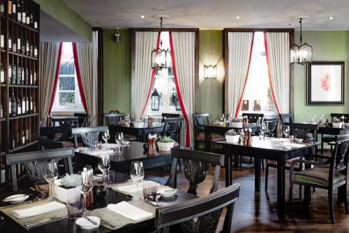 a dining room with tables and chairs and windows at Althoff Grandhotel Schloss Bensberg in Bergisch Gladbach