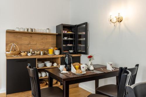 una sala da pranzo con tavolo, sedie e bancone di Hotel Annet garni a Meerane