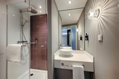 a bathroom with a sink and a shower with a mirror at Premier Inn Berlin City Centre in Berlin