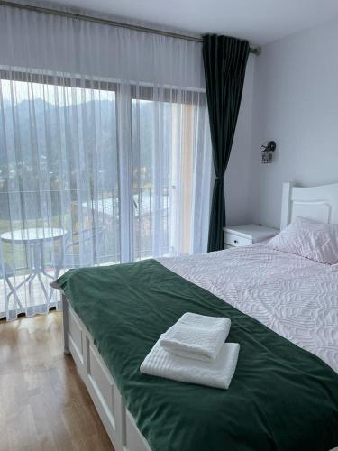 a bedroom with a bed and a large window at Silver Mountain Villa Colibita in Colibiţa