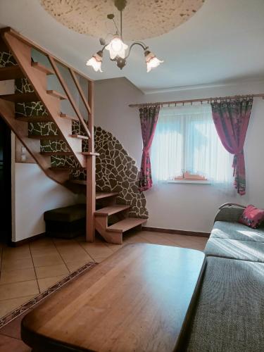 a living room with a spiral staircase and a couch at Domki w Bieszczadach in Polańczyk