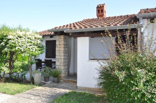 una casa blanca con techo rojo en Apartments Medulin, en Medulin