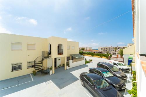a group of cars parked in a parking lot in front of a building at Hostal Miramar in Los Caños de Meca