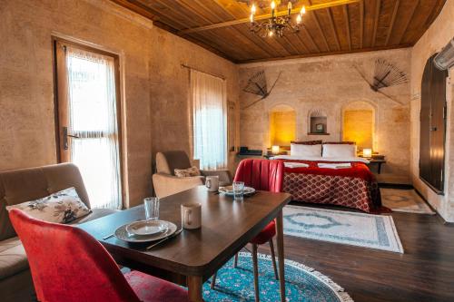 a hotel room with a bed and a table and chairs at Adelya Cave Hotel Apartments in Göreme