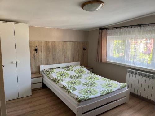 a small bedroom with a bed and a window at Willa Safra Szczawnica in Szczawnica