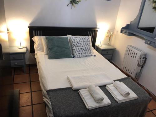 une chambre avec un grand lit avec des serviettes dessus dans l'établissement Apartamento familiar en Toledo, con 2 dormitorios, camas de matrimonio, ideal ubicación y fantàsticas vistas, à Tolède