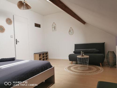 1 dormitorio con 1 cama y 1 sofá en 2 chambres privatives avec Sdb proche circuit en Arnage