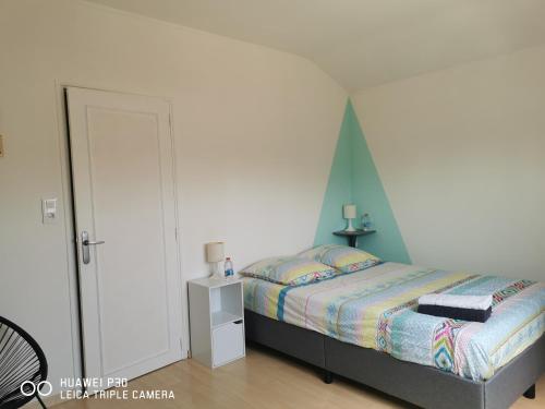 - une chambre avec un lit et un mur blanc dans l'établissement 2 chambres privatives avec Sdb proche circuit, à Arnage