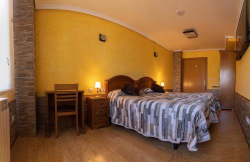 a bedroom with a bed and a table and a chair at Legaire Etxea in Ibarguren
