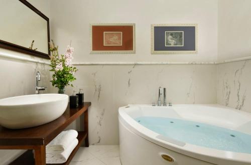 a white bathroom with a tub and a sink at Relais Villa Monte Solare Wellness & SPA in Panicale