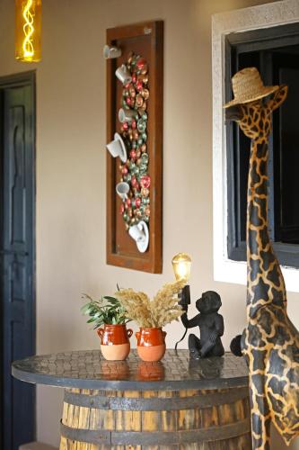 a giraffe standing next to a table with plants at Riad Anyssates in Marrakech