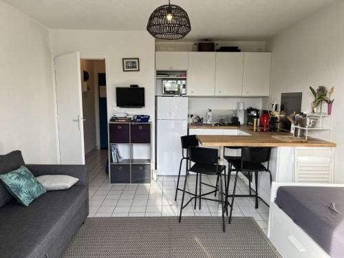 une cuisine et un salon avec une table et un canapé dans l'établissement Studio avec jardinet, proche plage et commerces, La Guérinière - FR-1-224B-594, à La Guérinière