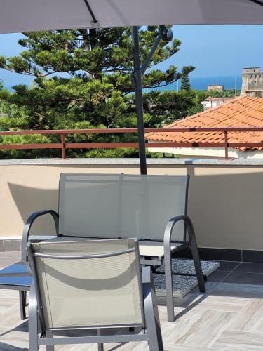 a table and chair under an umbrella on a patio at REDAMARE SUITE in Lago Patria