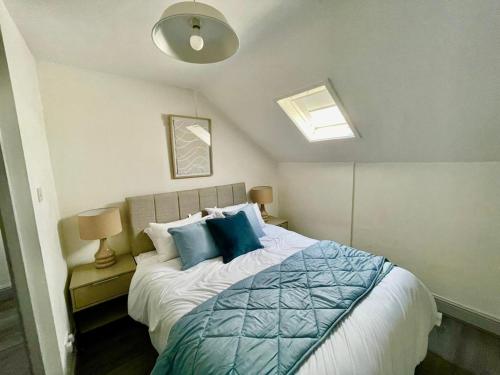 a bedroom with a large bed with blue pillows at Newly Renovated Apartments in Liverpool - Extended Stay in Liverpool