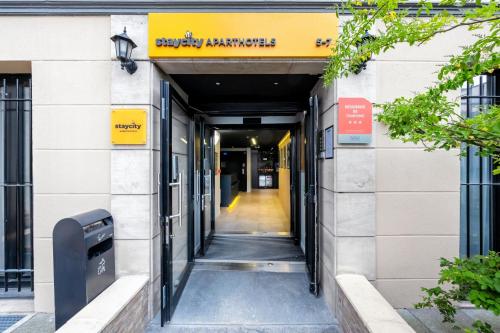 un pasillo que conduce a un edificio con una señal amarilla en Staycity Aparthotels Paris Gare de l'Est, en París