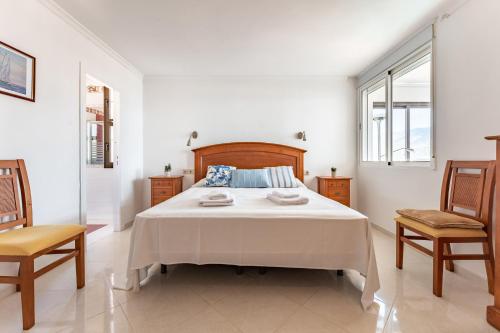 - une chambre blanche avec un lit et deux chaises dans l'établissement MalagaSuite Skyviews Fuengirola, à Fuengirola