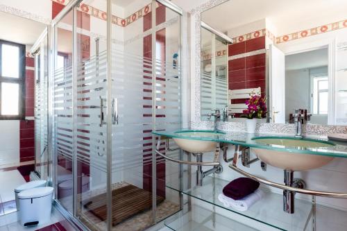 La salle de bains est pourvue de 2 lavabos et d'une douche. dans l'établissement MalagaSuite Skyviews Fuengirola, à Fuengirola