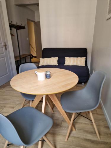 a wooden table with chairs and a coffee cup on it at Appartement au coeur de Vezelay - GALERIE 10 in Vézelay