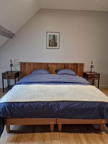 a bedroom with a large bed with blue sheets at Appartement au coeur de Vezelay - GALERIE 10 in Vézelay