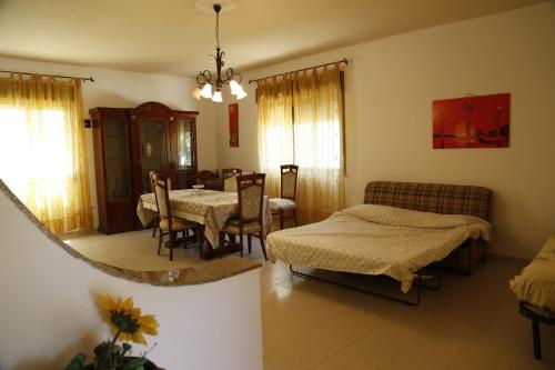 a living room with two beds and a dining room at Villa Giù, indipendent villa near airport and sea in Cinisi
