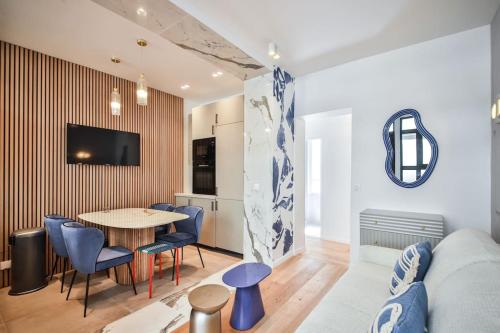 un salon avec une table et des chaises bleues dans l'établissement Appart 6Pers#2 Chambres#Beaugrenelle#Paris 15#AC, à Paris