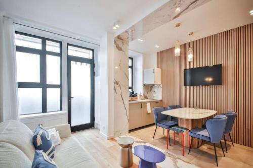 un salon avec une table et des chaises bleues dans l'établissement Appart 6Pers#2 Chambres#Beaugrenelle#Paris 15#AC, à Paris