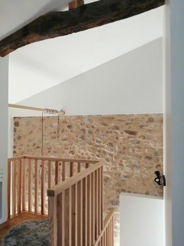Cette chambre est dotée d'un escalier et d'un mur en pierre. dans l'établissement Gite romantique de la Ferme du Pral, à Saint-Victor