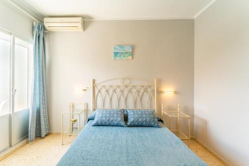 a bedroom with a bed with a blue bedspread at Hostal Miramar in Los Caños de Meca