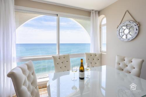 jadalnia ze stołem i krzesłami oraz dużym oknem w obiekcie Apartment AGUAMARINA on the beach front w Maladze