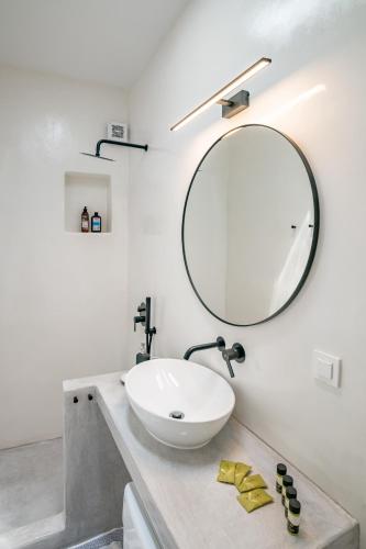 a bathroom with a white sink and a mirror at Sandy Studio With View In Naousa in Naousa