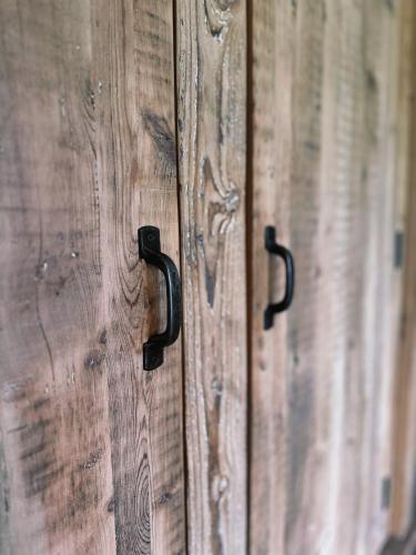 a pair of wooden doors with black handles at The Vila Bled Premium Luxury Retreat in Bled