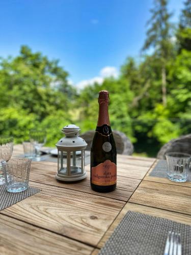 a bottle of wine sitting on top of a wooden table at The Vila Bled Premium Luxury Retreat in Bled