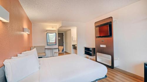 a bedroom with a white bed and a television at Suites Los Angeles CA Los Angeles LAX in Inglewood