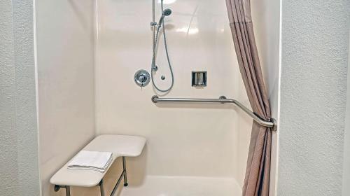 y baño con ducha, aseo y taburete. en Suites Los Angeles CA Los Angeles LAX, en Inglewood