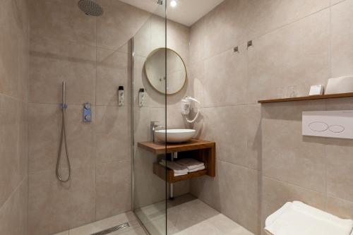 a bathroom with a shower and a sink and a mirror at Amsterdam Hotel Uithoorn in Uithoorn