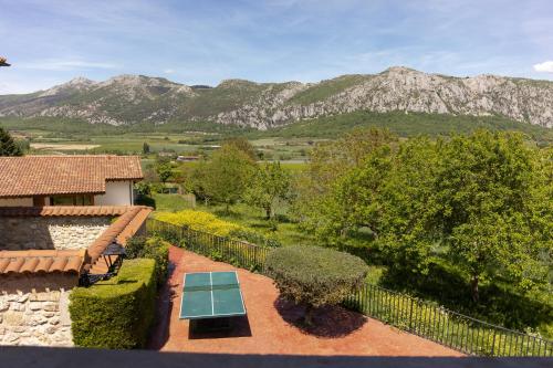 a garden with a table and a view of mountains at Legaire Etxea in Ibarguren