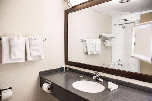 a bathroom with a sink and a mirror and towels at Wyndham Edmonton Hotel and Conference Centre in Edmonton
