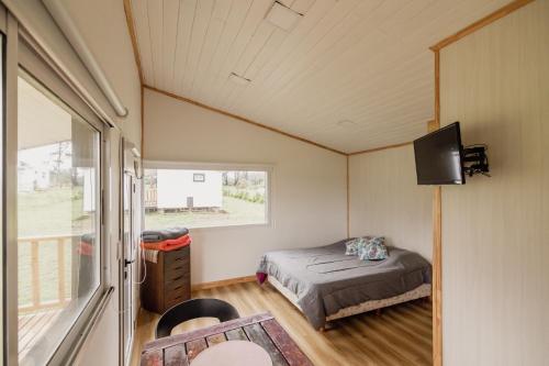 una piccola camera da letto con un letto e una finestra di Tiny House Pura Vida Chapadmalal a Colonia Chapadmalal