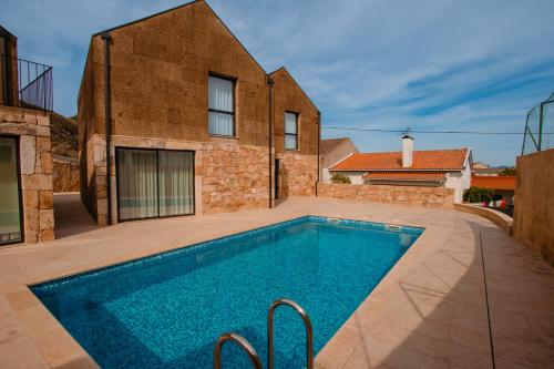 a swimming pool in the backyard of a house at Chalês - Maria Alva in Marialva