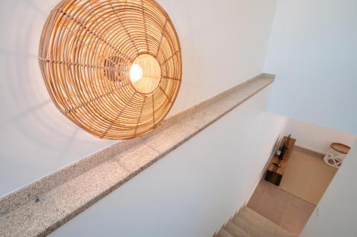 a wicker basket hangs from the ceiling of a staircase in a house at Chalês - Maria Alva in Marialva