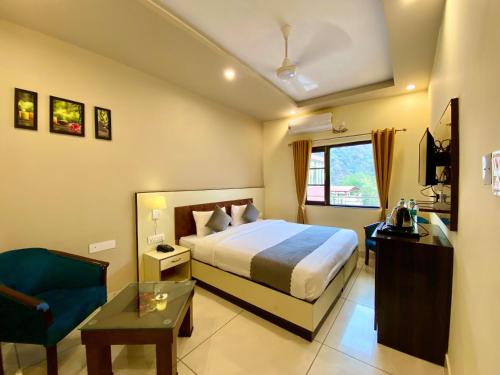 a hotel room with a bed and a blue chair at Tapovan New Residency - 5 minutes walk to Laxman jhula in Rishīkesh