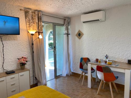 - une chambre avec un bureau et une table avec des chaises dans l'établissement Cassetta 92 Marie-Pierre, à Lumio