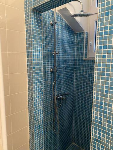 y baño con ducha de azulejos azules. en Apartman Elli, en Zagreb