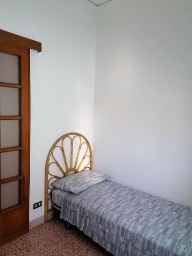 a bedroom with a bed and a wooden door at Appartamenti I Mulini in Trapani