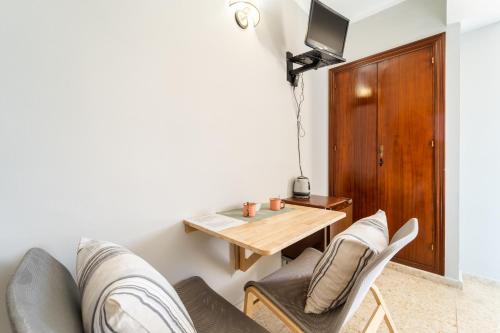 a living room with a wooden table and chairs at Hostal Miramar in Los Caños de Meca