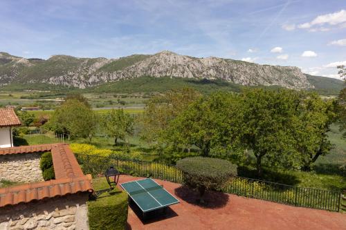 a tennis court sitting on top of a roof with mountains at Legaire Etxea in Ibarguren